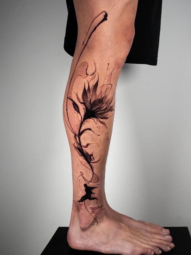 Abstract flower and running figure calf tattoo