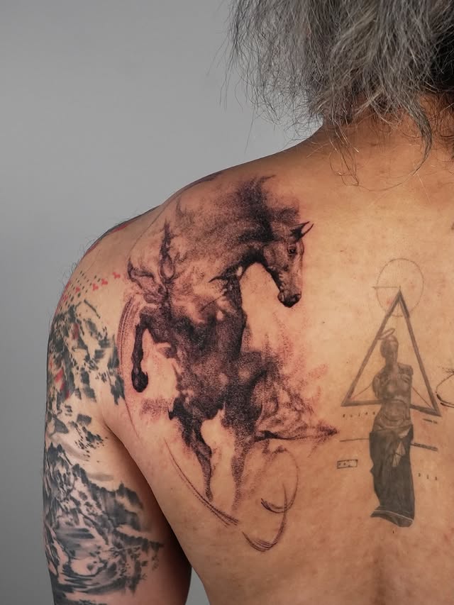 Ink-wash horse shoulder tattoo with geometric statue design