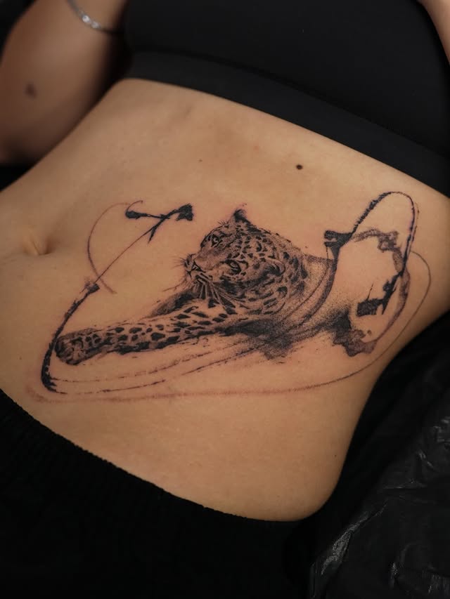 Leopard tattoo on side with fine line accents