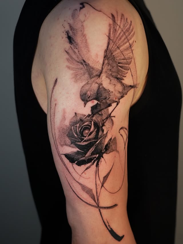 Bird and rose upper arm tattoo