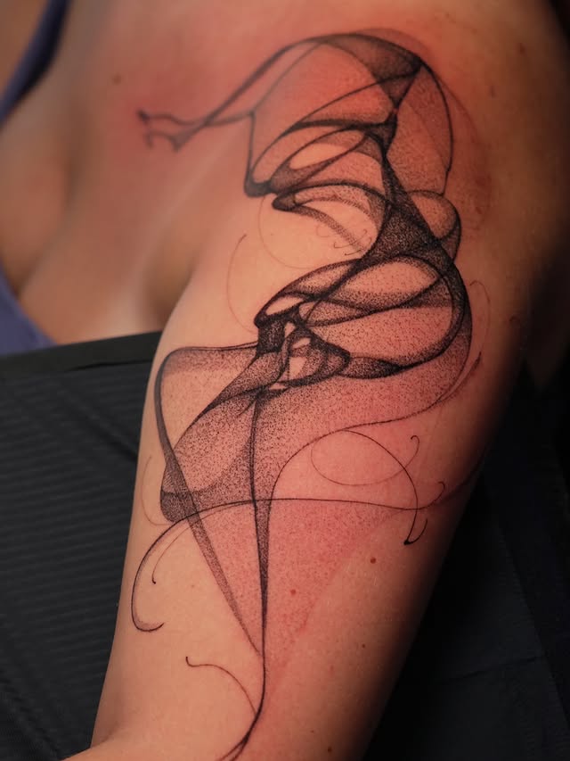 Abstract flowing line upper arm tattoo